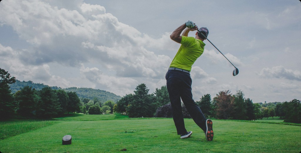 Golfer teeing off on a fairway
